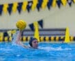 Water polo athlete prepares to throw a yellow water polo ball, showcasing skill and determination in the pool.