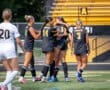 Cheering girls’ soccer team celebrates a goal on the field, highlighting teamwork and sportsmanship in action.