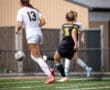 Two female soccer players in action on a field, focusing on ball control and teamwork during a game.