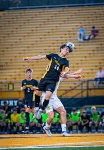 High school soccer players compete for the ball in an action-packed game, showcasing skill and teamwork.