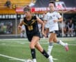 High school soccer players compete on the field, showcasing athleticism and teamwork during a match.