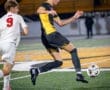 Soccer players compete for the ball on the field during a night match, showcasing action and athleticism.