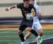 High school soccer players compete for the ball on the field, showcasing athleticism and teamwork during the match.