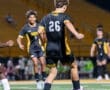 High school soccer players in action, focusing on a player in jersey number 26 dribbling the ball on the field.