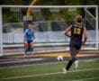 Player #19 of the Tigers dribbles the soccer ball toward the goal, with the goalie ready for action in the background.