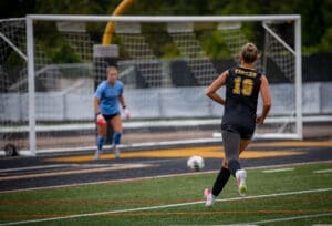 Player #19 of the Tigers dribbles the soccer ball toward the goal, with the goalie ready for action in the background.