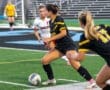 Soccer players compete on the field; one dribbles the ball while opponents strategize. Exciting sports action captured!