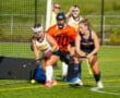 Field hockey players in action during a game, showcasing teamwork and competitive spirit on the turf.