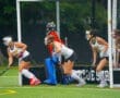 Field hockey players prepare for action during a match, showcasing teamwork and athleticism on the turf.