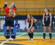 Girls' field hockey players celebrate as one jumps in enthusiasm during a practice session on the field.