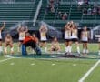 Girls' field hockey team celebrating on the field, showcasing team spirit and athleticism during a game.
