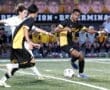 High school soccer players compete for the ball on a field, showcasing teamwork and athleticism during a match.