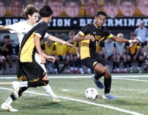 High school soccer players compete for the ball on a field, showcasing teamwork and athleticism during a match.