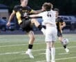 High school soccer players clash during a match, highlighting competitive gameplay and athleticism on the field.