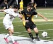 High school soccer match where players from Central and Tigers compete for the ball under stadium lights.