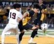 High school soccer players compete for the ball under stadium lights, showcasing dynamic athleticism and teamwork.