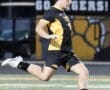 High school soccer player in action, kicking a soccer ball on the field during a game. Energetic and focused moment.