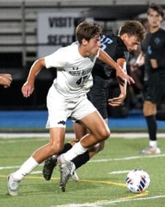 North Allegheny soccer player dribbles the ball during a competitive high school match against an opposing team.