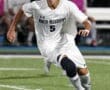 North Allegheny soccer player sprinting on the field, focused on the ball during an evening match.