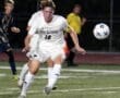 North Allegheny soccer player #16 sprinting toward the ball during a competitive game under stadium lights.