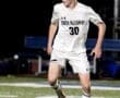 North Allegheny soccer player in action, dribbling the ball on a well-lit field during a night game.