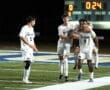 North Allegheny soccer team celebrates a goal under stadium lights, with 24 seconds left in the game. Scoreboard shows 0-3.