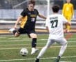 Soccer players compete fiercely on the field, with a Tiger player attempting to kick the ball past a Dragon opponent.