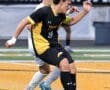 Soccer players compete during a match on a field, highlighting dynamic movement and athleticism in the game.