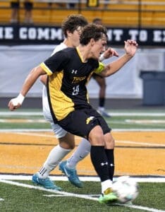 Soccer players compete during a match on a field, highlighting dynamic movement and athleticism in the game.