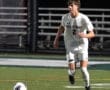 North Allegheny soccer player in action on the field, dribbling the ball under stadium lights during a match.