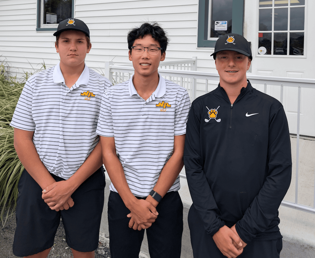 Three young male golfers pose together, wearing matching golf shirts and caps, in front of a building.