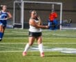 Field hockey player takes a shot during a match, showcasing skill and determination on the turf.