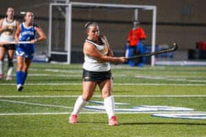 Field hockey player takes a shot during a match, showcasing skill and determination on the turf.