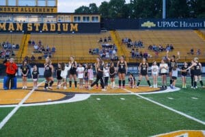 Girls' soccer team celebrates with young fans at North Allegheny Stadium, showcasing community spirit and teamwork.