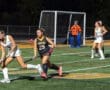 Field hockey players compete under stadium lights, showcasing dynamic action and teamwork on the turf.