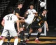 High school soccer players compete for the ball in a thrilling match, showcasing athleticism and teamwork.