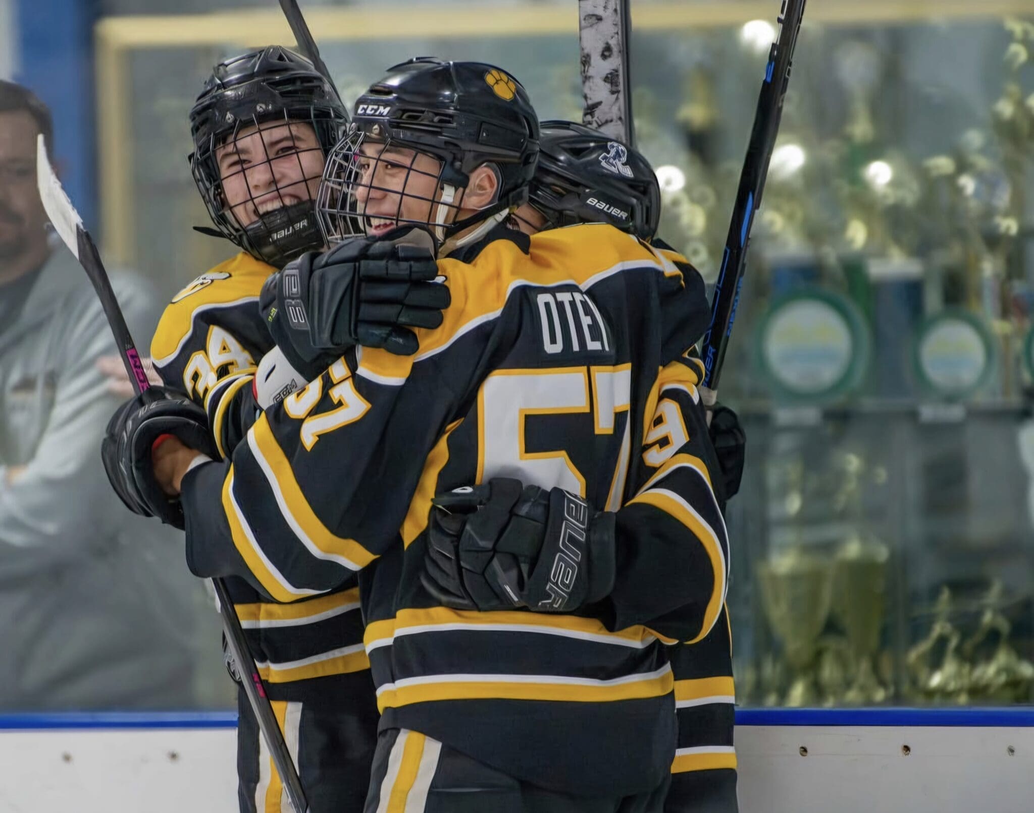 Youth hockey players celebrate a goal with joy and camaraderie, showcasing teamwork on the ice.